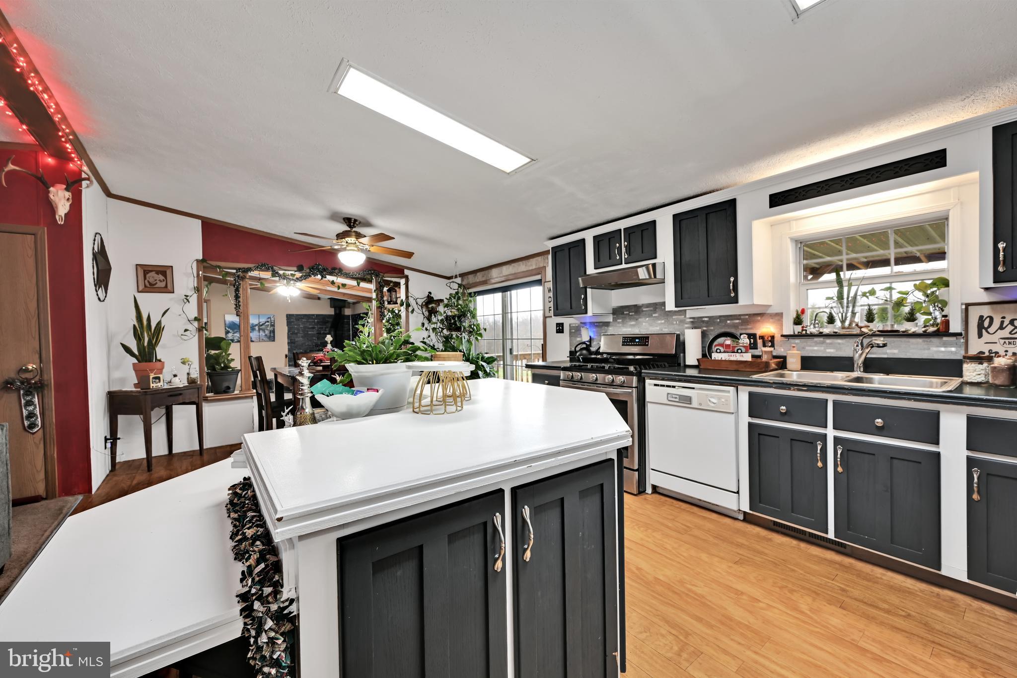 60 Bordnersville Road Jonestown, PA 17038 - Photo 22 of 45 a kitchen with stainless steel appliances granite countertop a stove top oven a sink dishwasher a dining table and chairs with wooden floor