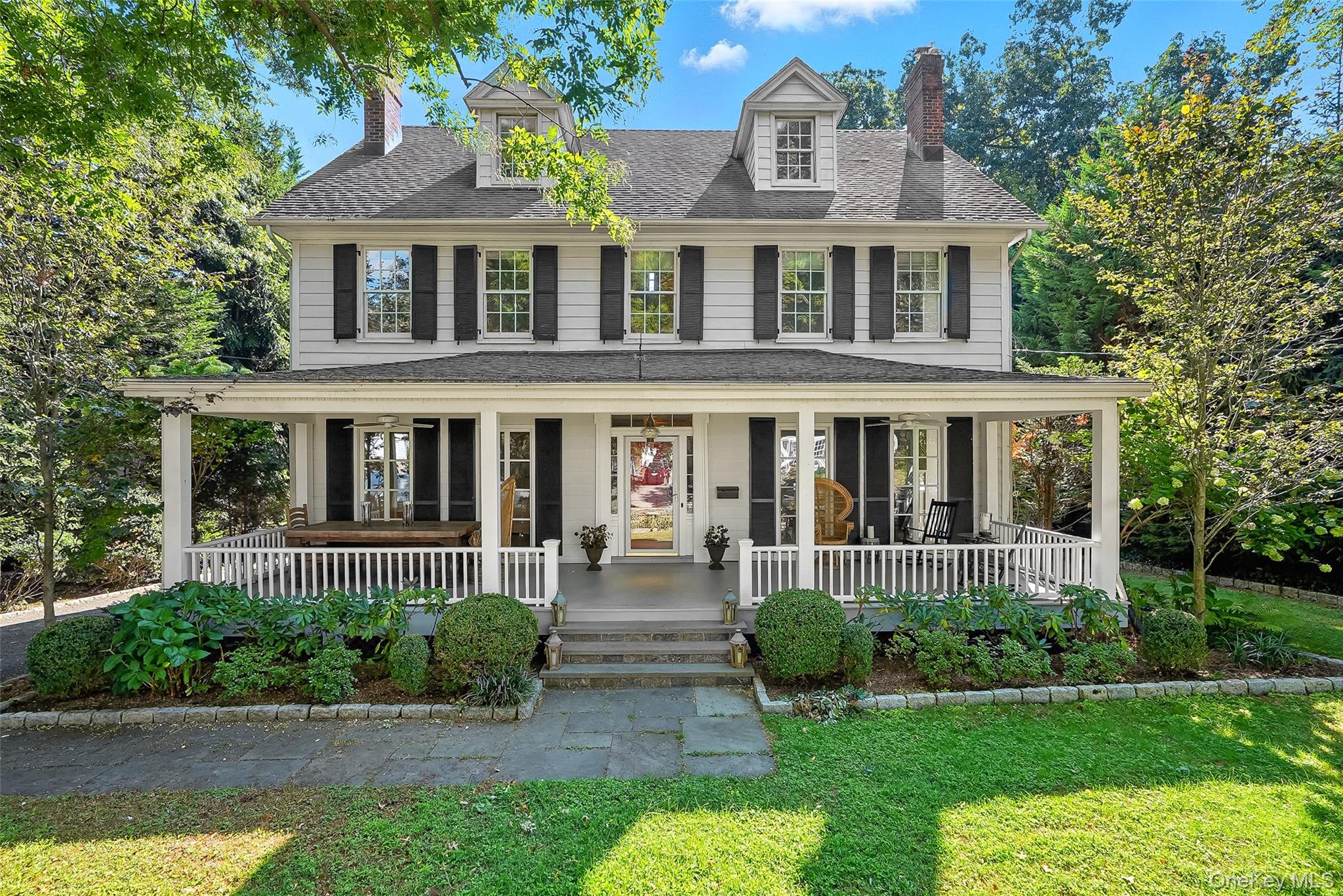 front view of a brick house with a yard