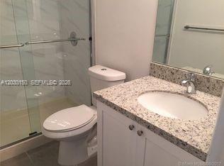 11206 Southwest 125th Place, Unit 11206 Miami, FL 33186 - Photo 7 of 15 a bathroom with a granite countertop toilet a sink and a mirror