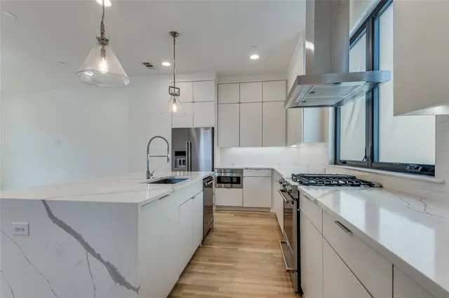 a kitchen with stainless steel appliances granite countertop a sink stove and refrigerator