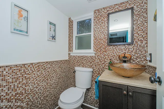 a bathroom with a toilet a sink and mirror