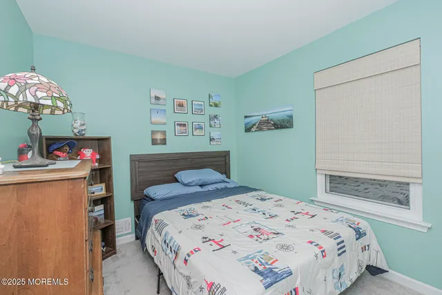 a bedroom with a bed and a dresser in it