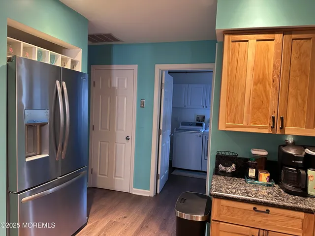 a kitchen with granite countertop stainless steel appliances a refrigerator and cabinets