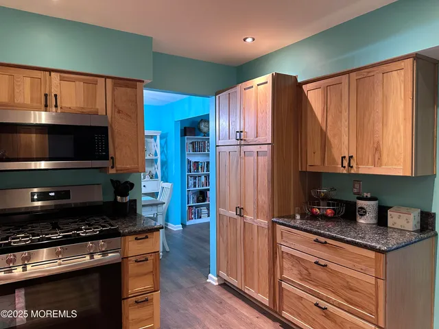 a kitchen with granite countertop a refrigerator stove and microwave