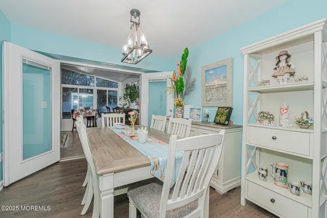 a view of a dining room with furniture a chandelier and wooden floor