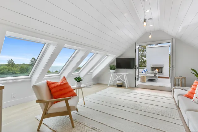 a living room with furniture a flat screen tv and a floor to ceiling window