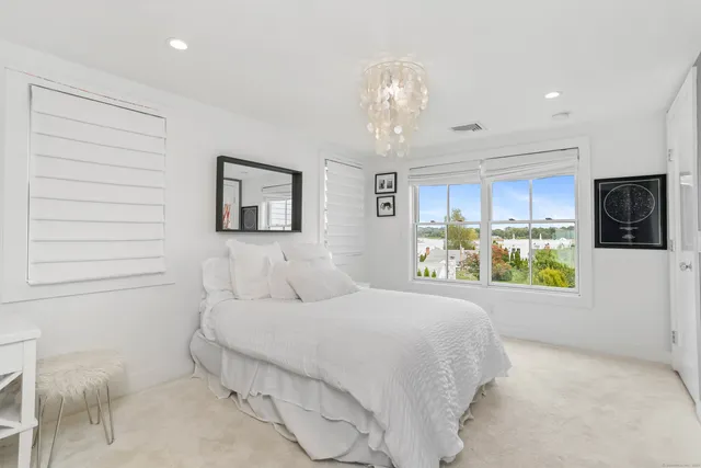 a spacious bedroom with a bed and a chandelier