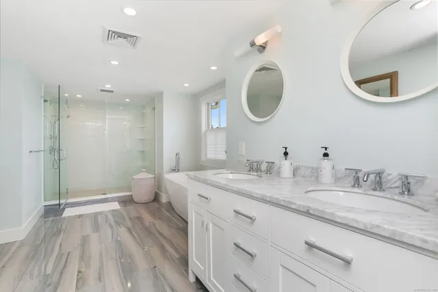 a spacious bathroom with a granite countertop sink a toilet and a mirror