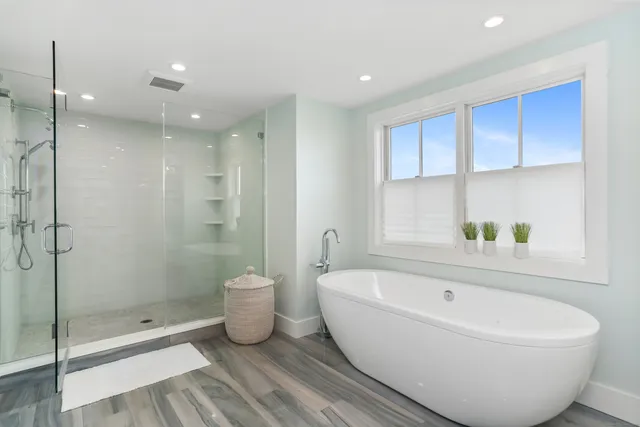 a white bath tub sitting next to a shower