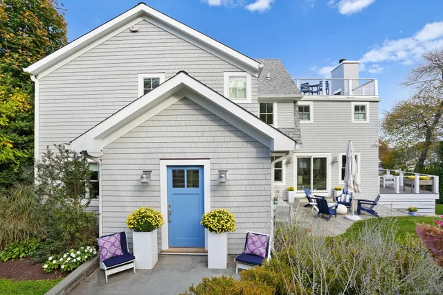 a front view of a house with patio and a garden