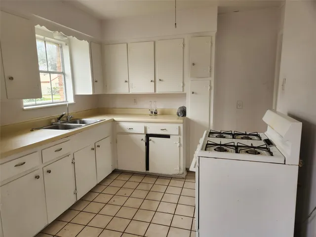 a kitchen with cabinets appliances a sink and a window