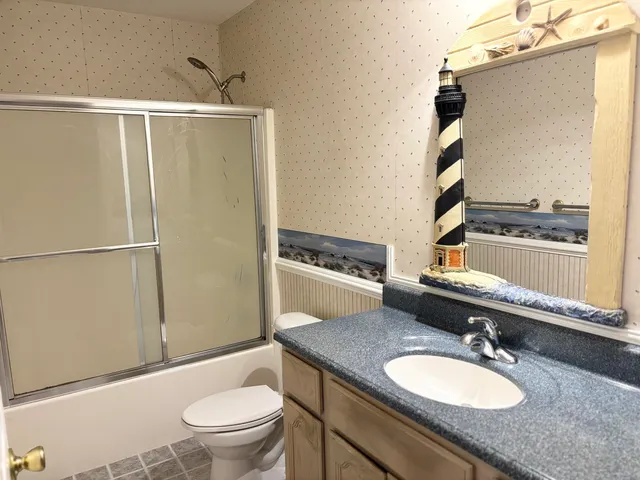 a bathroom with a granite countertop sink toilet and shower