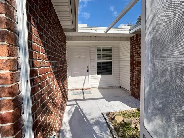 a view of a patio with a table and chairs and potted plants
