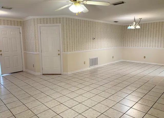 an empty room with fan and windows