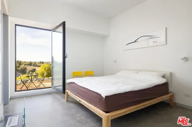 a bed sitting in a bedroom next to a window