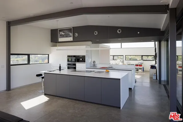 a kitchen with stainless steel appliances granite countertop a sink a stove and a refrigerator