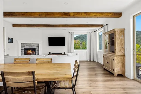 a kitchen with stainless steel appliances kitchen island granite countertop a refrigerator a stove a microwave oven with white cabinets and wooden floor