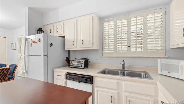 a kitchen with a refrigerator and a sink