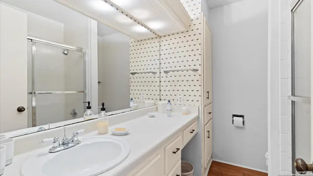 a bathroom with a sink double vanity granite tub shower and a mirror