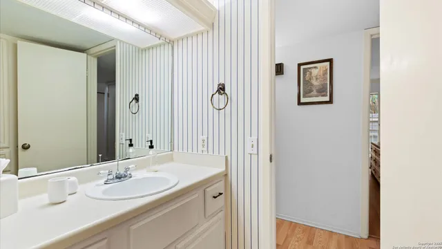 a bathroom with a granite countertop sink and a mirror