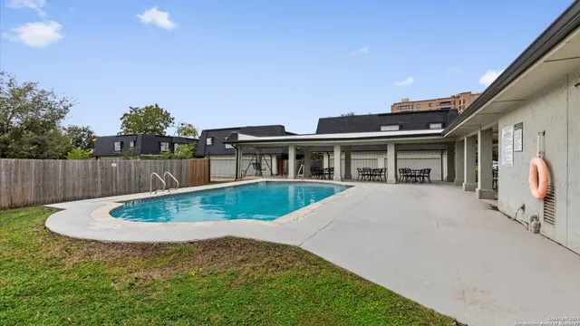 a view of a house with backyard and sitting area