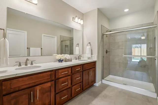 a bathroom with a double vanity sink mirror double and shower