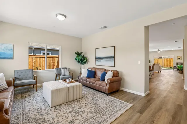 a living room with furniture and a wooden floor