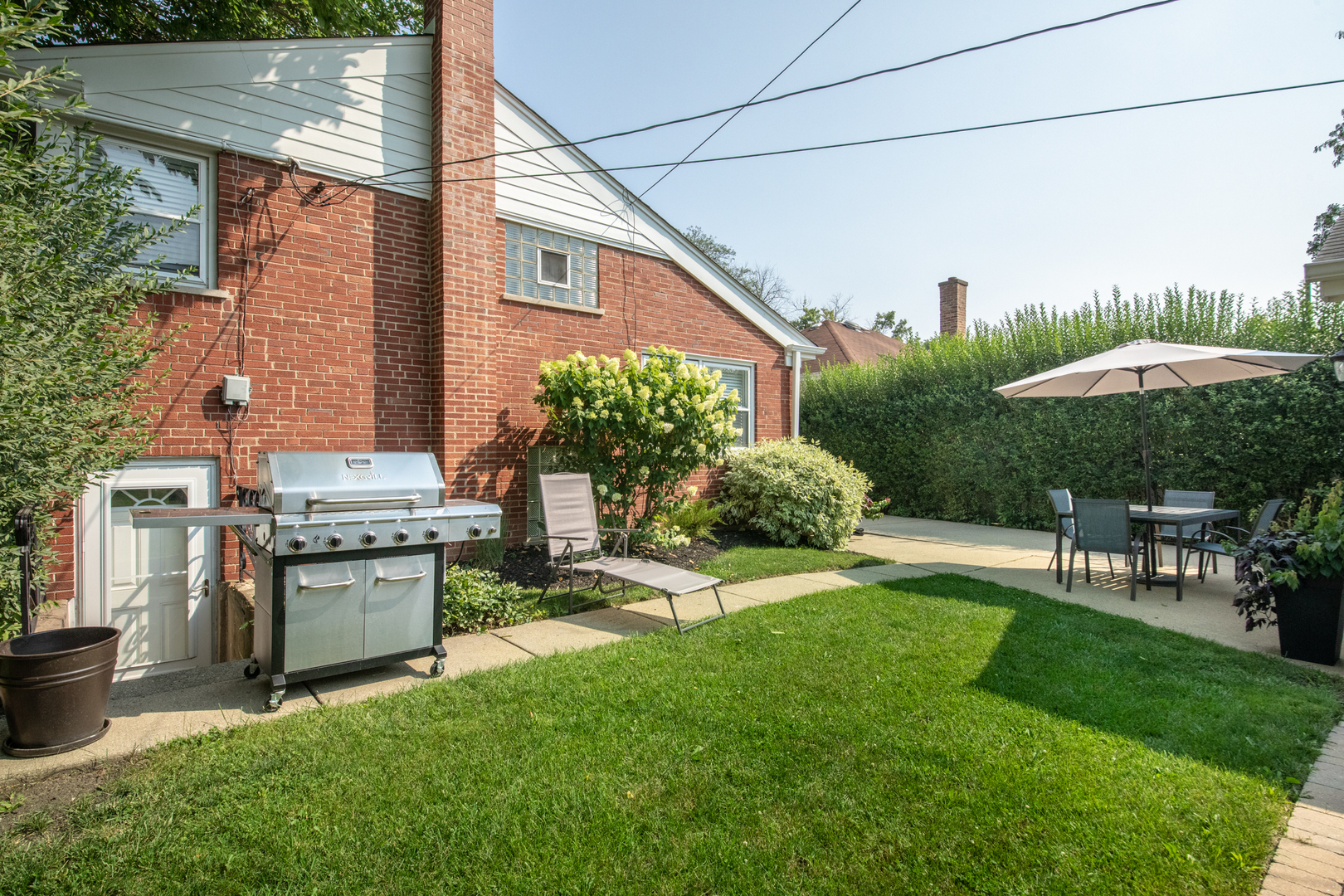 900 Rowe Avenue Park Ridge, IL 60068 - Photo 20 of 32 a backyard of a house with table and chairs under an umbrella