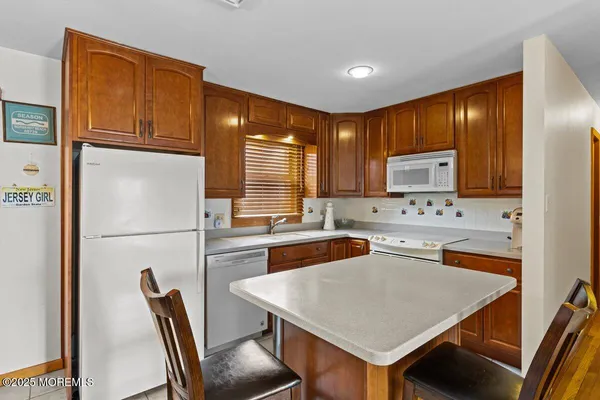 a kitchen with stainless steel appliances granite countertop a refrigerator a stove a sink a dining table and chairs