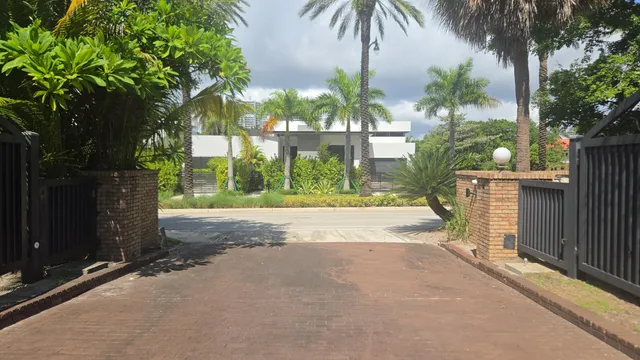 an aerial view of a house with outdoor space and trees all around