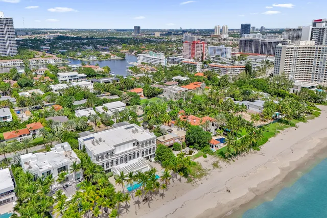 an aerial view of residential houses with outdoor space and trees all around