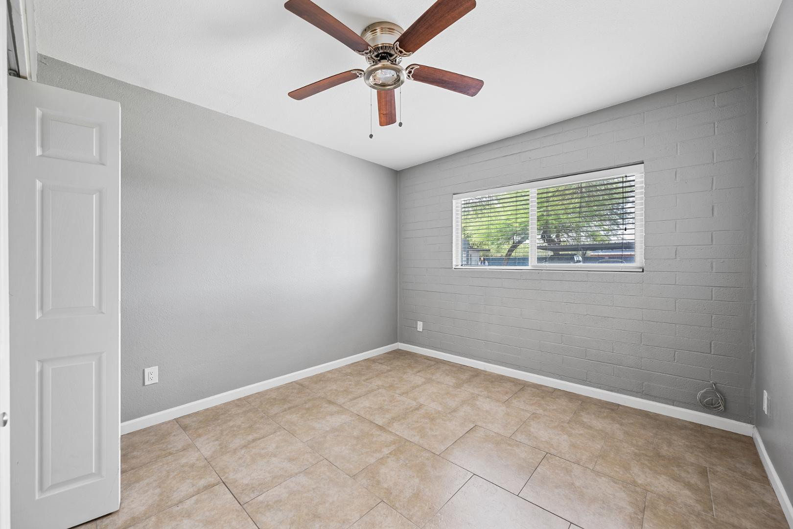 1518 West Colter Street, Unit 31 Phoenix, AZ 85015 - Photo 8 of 11 an empty room with windows and fan