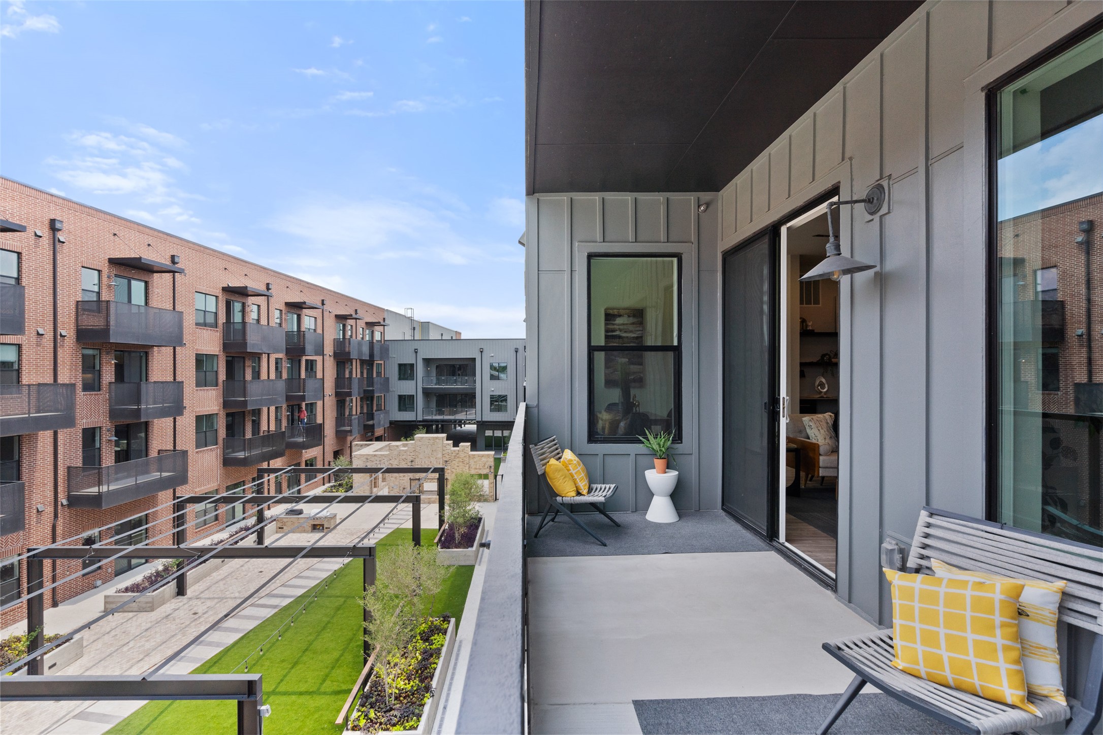 4510 Terry-O Lane, Unit 341 Austin, TX 78745 - Photo 39 of 40 The property features a private balcony with modern exterior siding, a sliding glass door, and an exterior light fixture