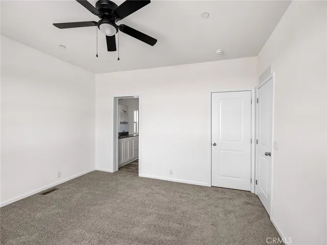 an empty room with chandelier fan