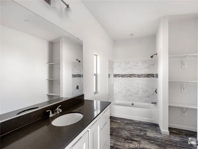 a bathroom with a granite countertop sink mirror and a bathtub