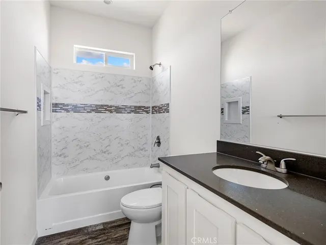 a bathroom with a granite countertop sink toilet and shower