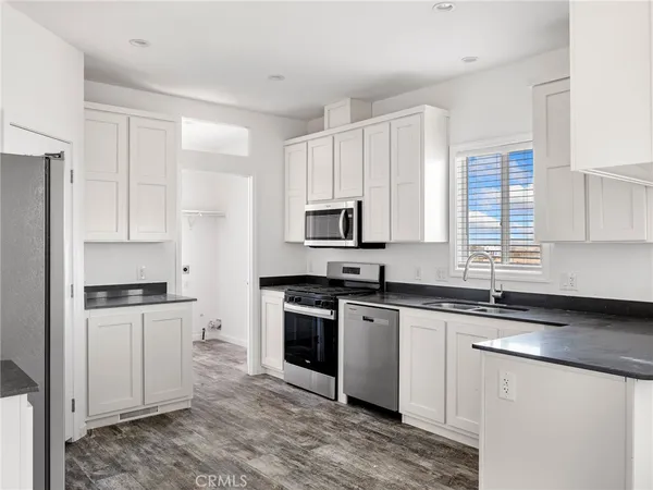 a kitchen with stainless steel appliances granite countertop a stove a sink and a microwave