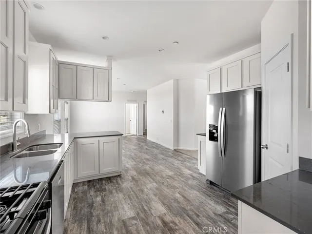 a kitchen with stainless steel appliances granite countertop a refrigerator sink and stove