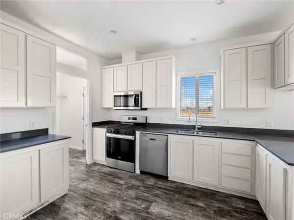 a kitchen with stainless steel appliances granite countertop a sink stove and cabinets