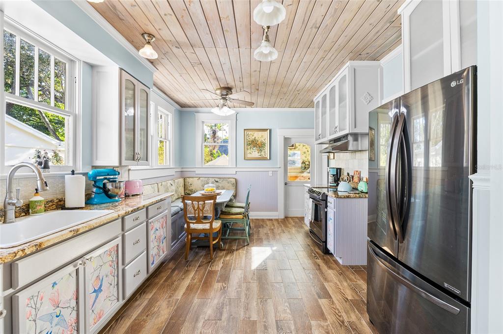 212 South Coolidge Avenue Tampa, FL 33609 - Photo 5 of 6 a kitchen with stainless steel appliances a refrigerator a sink dishwasher a stove and white countertops with wooden floor