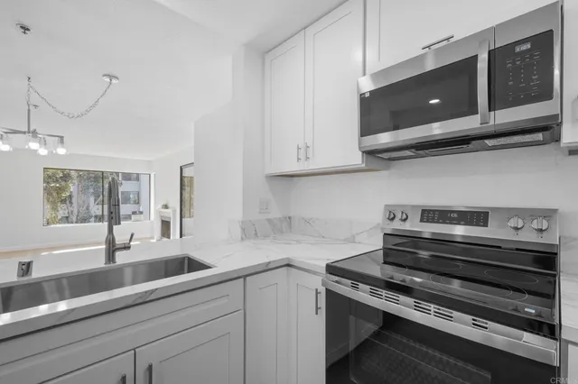 a kitchen with stainless steel appliances granite countertop a sink a stove and microwave