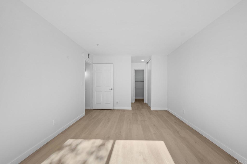 5745 Friars Road, Unit 116 San Diego, CA 92110 - Photo 21 of 44 a view of a room with wooden floor and white walls