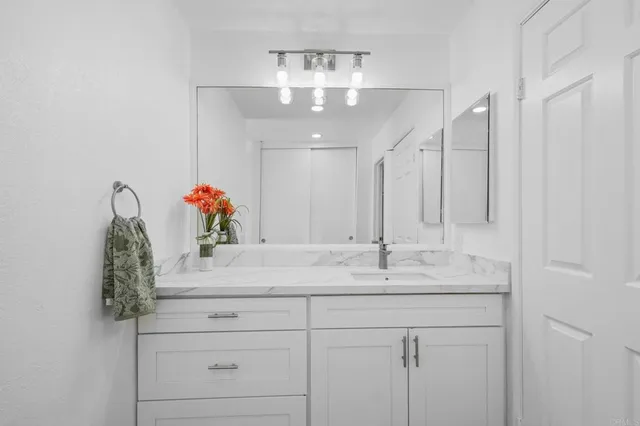 a bathroom with a sink vanity and a mirror