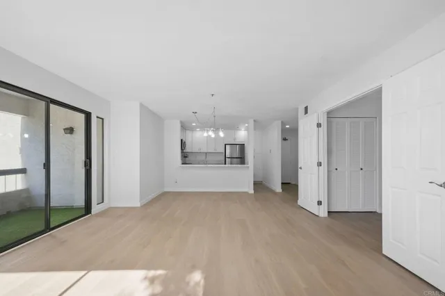 a view of a big room with wooden floor and windows