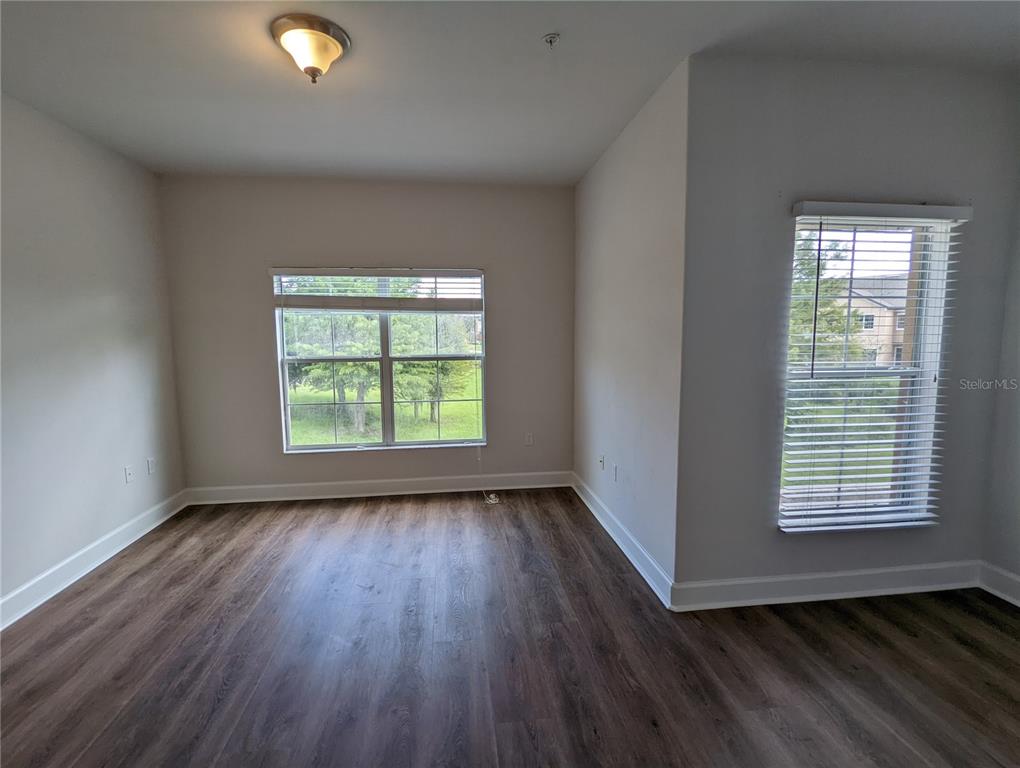 7782 Southwest 64th Lane, Unit 1002 Gainesville, FL 32608 - Photo 14 of 42 an empty room with wooden floor and windows