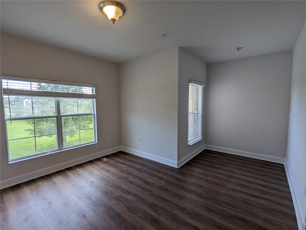 7782 Southwest 64th Lane, Unit 1002 Gainesville, FL 32608 - Photo 15 of 42 a view of an empty room with wooden floor and a window
