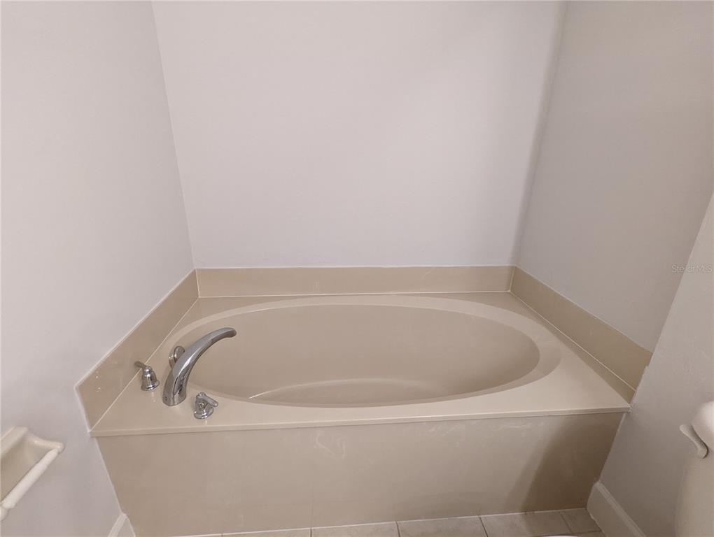 7782 Southwest 64th Lane, Unit 1002 Gainesville, FL 32608 - Photo 20 of 42 a white bath tub sitting in a bathroom