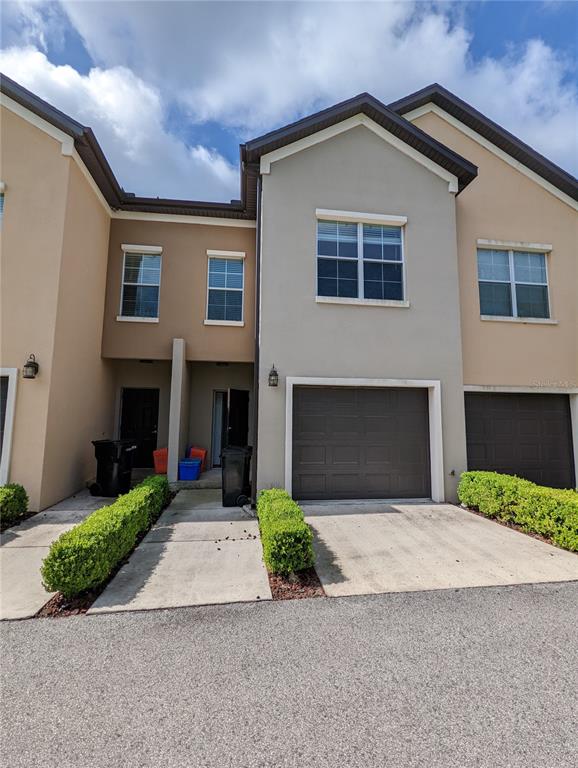 7782 Southwest 64th Lane, Unit 1002 Gainesville, FL 32608 - Photo 2 of 42 a front view of a house with a yard and garage