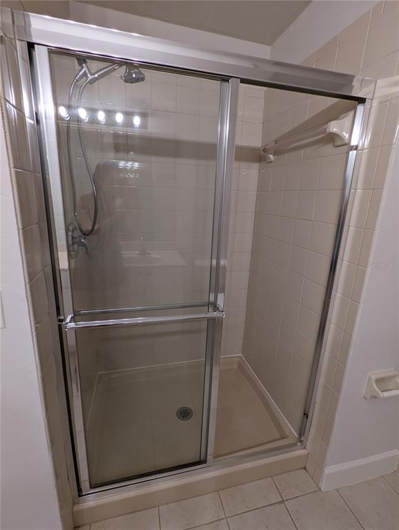 7782 Southwest 64th Lane, Unit 1002 Gainesville, FL 32608 - Photo 21 of 42 a bathroom with a glass shower door and mirror