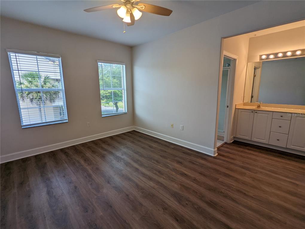 7782 Southwest 64th Lane, Unit 1002 Gainesville, FL 32608 - Photo 24 of 42 an empty room with wooden floor and windows